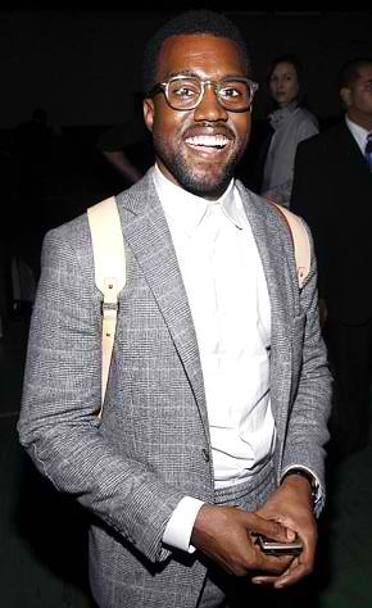 Il cantante rapper Kanye West, con occhiali a montatura spessa, zainetto e camicia abbottonata fino all&#39;ultimo bottone